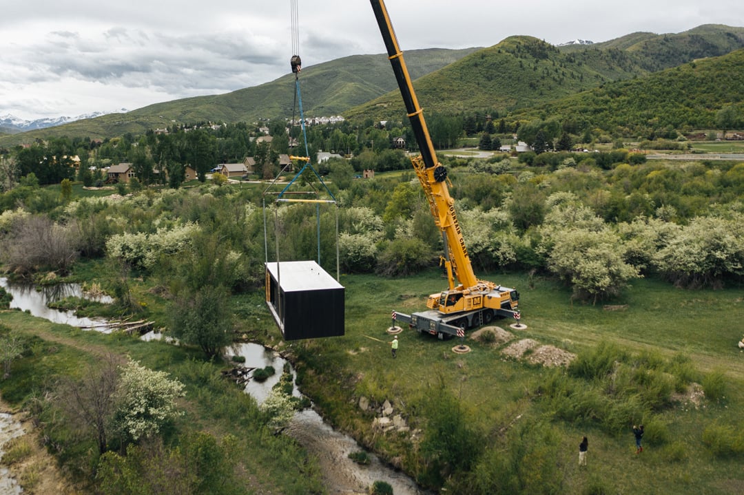 A construction crew craning a Modal 01 unit into place