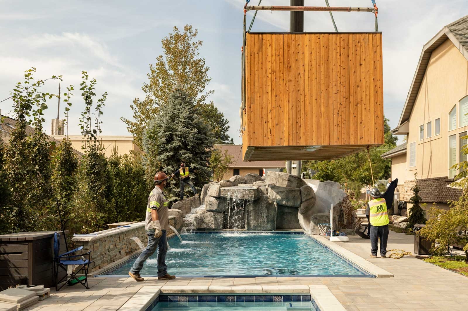 A Modal ADU being installed in a backyard near a pool 