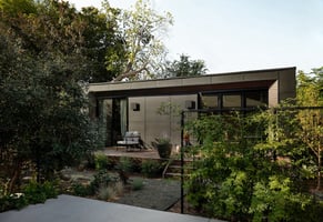 A Modal ADU in a backyard with trees and a garden