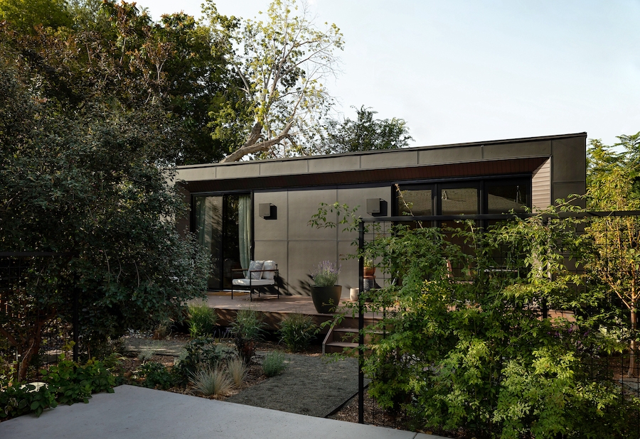 A Modal ADU in a backyard with trees and a garden 