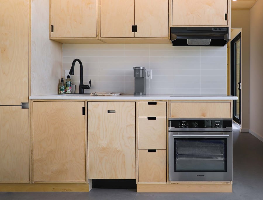 Small kitchen with birch cabinetry and white blacksplash