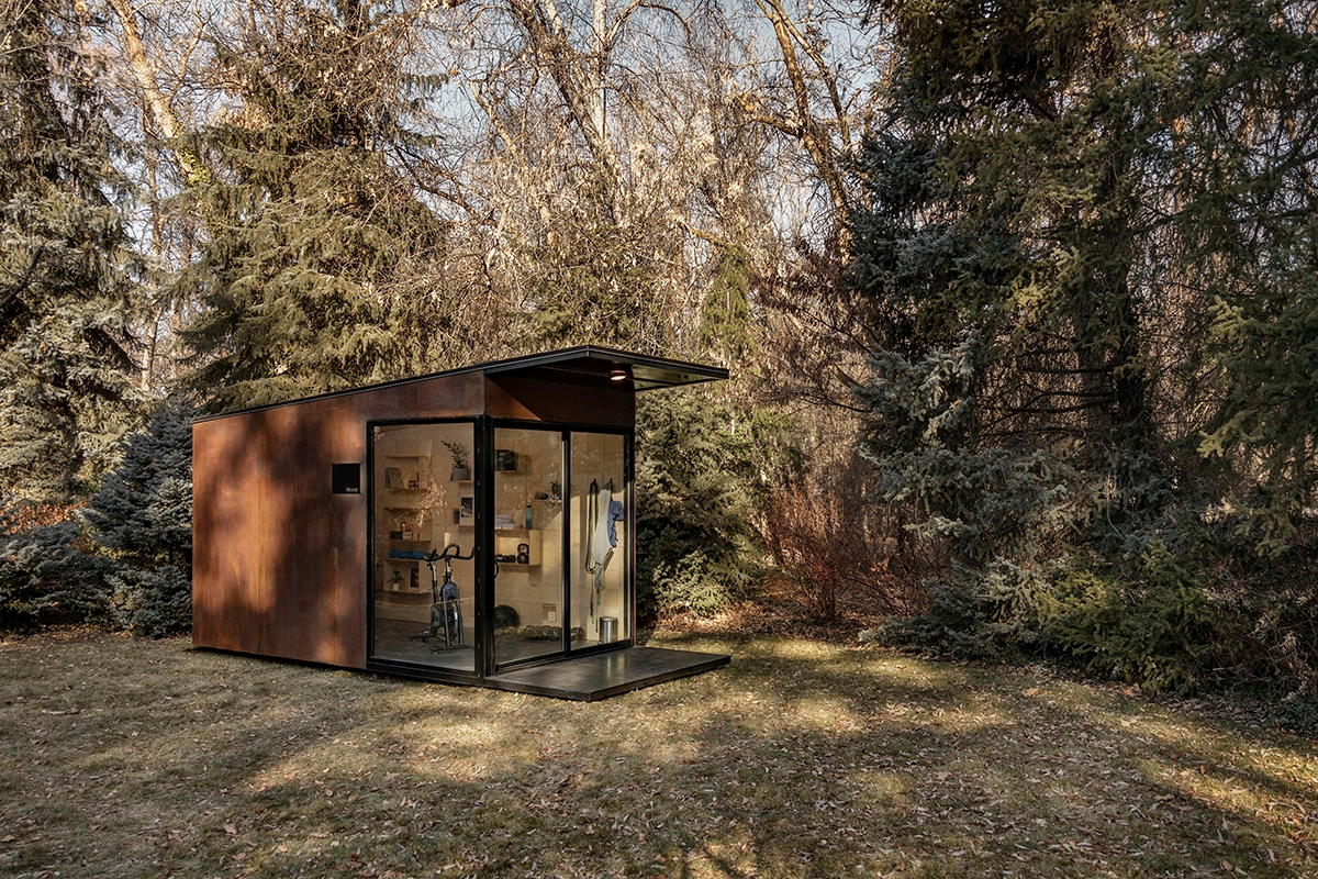 The Modal Pod in a backyard with pine trees