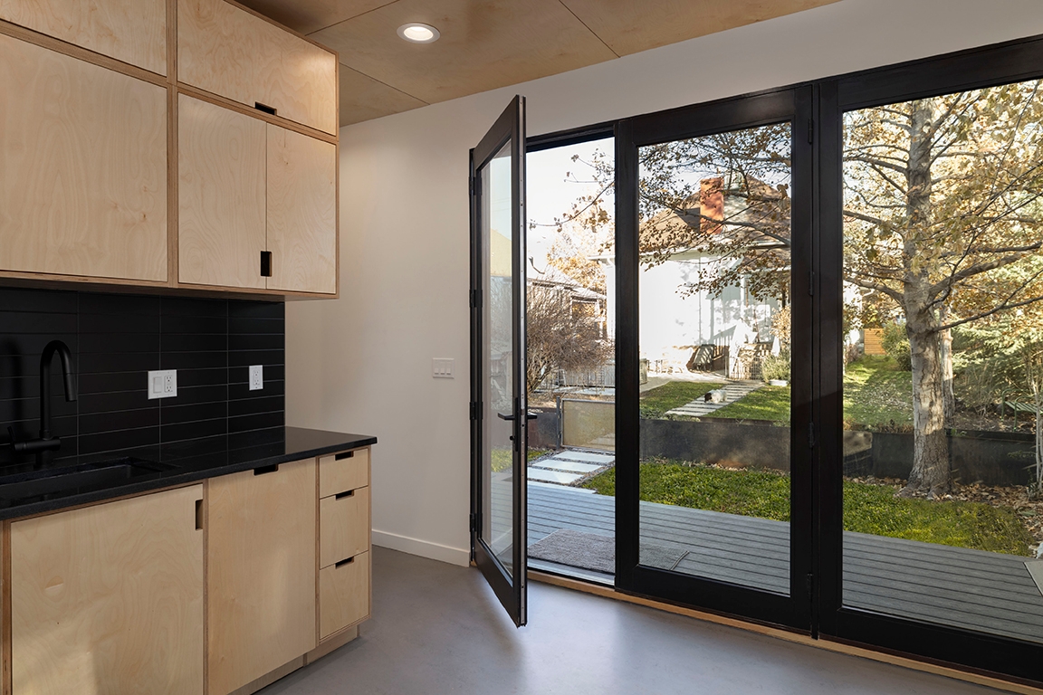 Interior of small home with wood cabinetry and black countertop