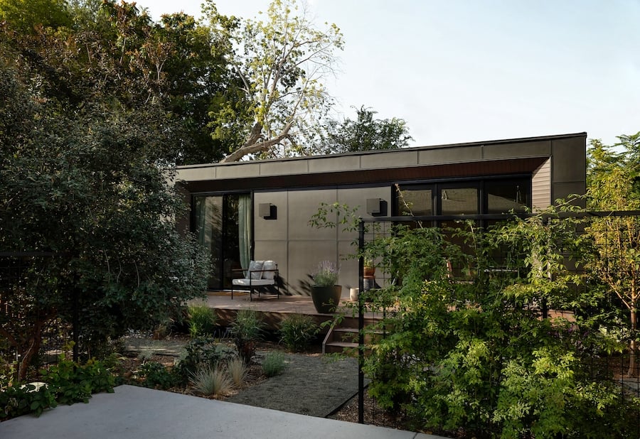 A mother-in-law suite from Modal in a backyard with trees and bushes