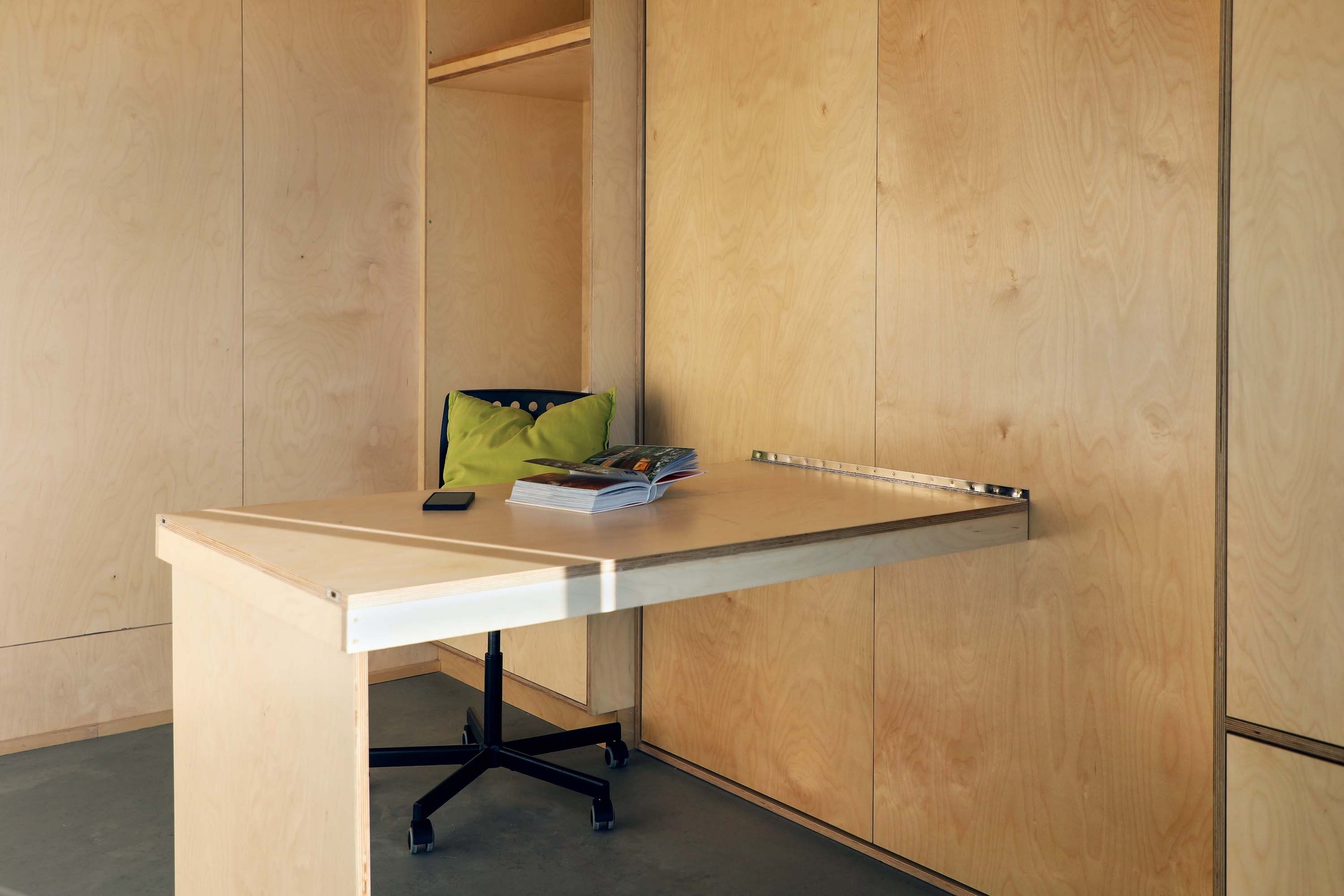 Small desk with open book and iPhone on top