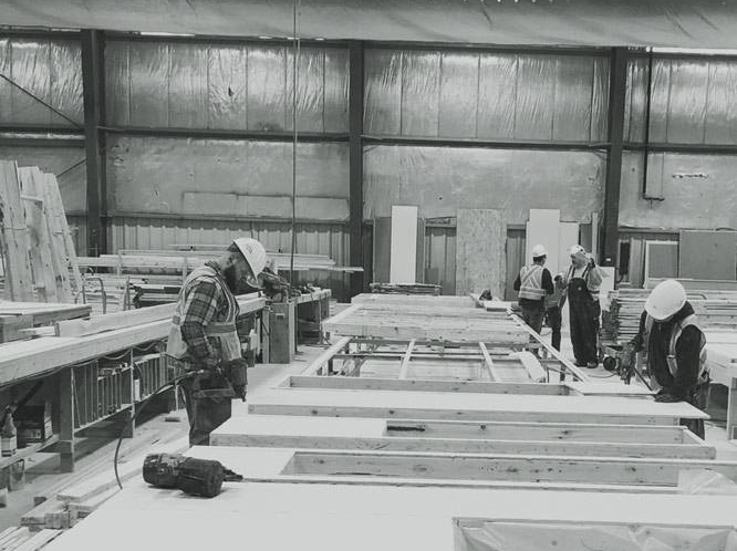 Black and white scene of Modal’s modular construction team assembling an accessory dwelling unit in a factory